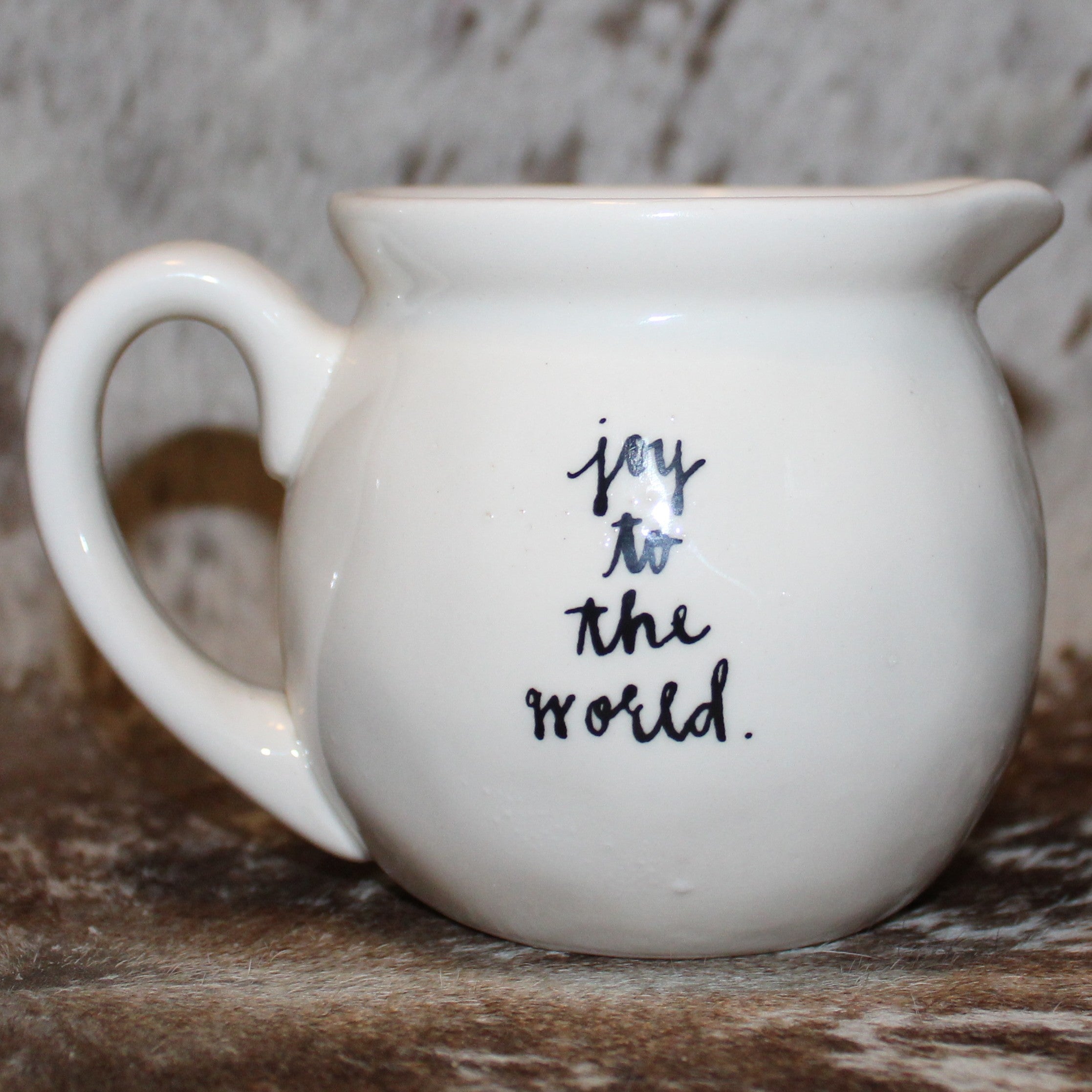 Rae Dunn give Creamer with Present on Front and joy to the world on back.
